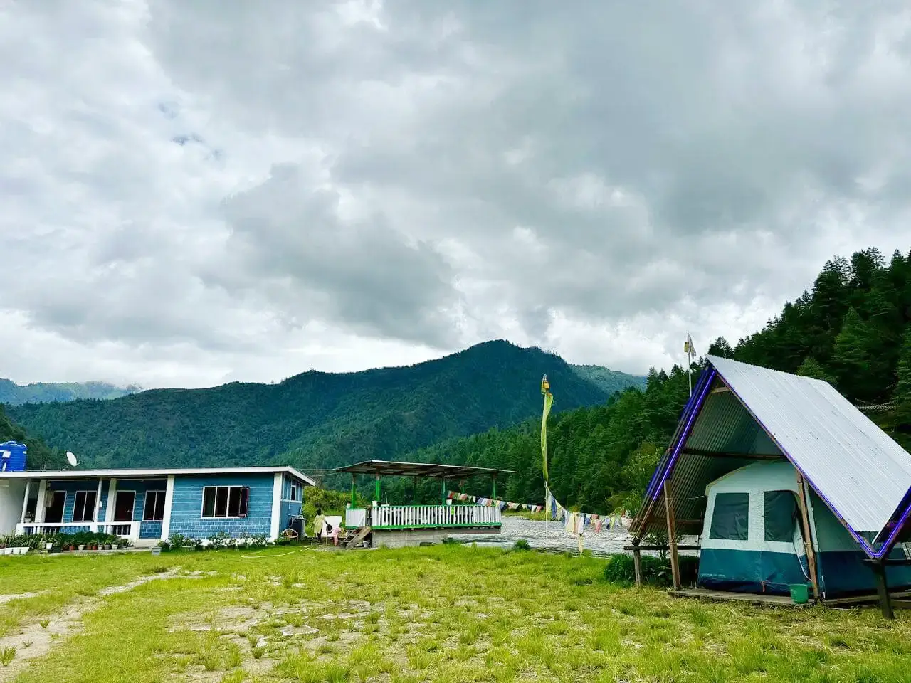 First tent setup with blue house in background at Sangti Tsomka Campsite
