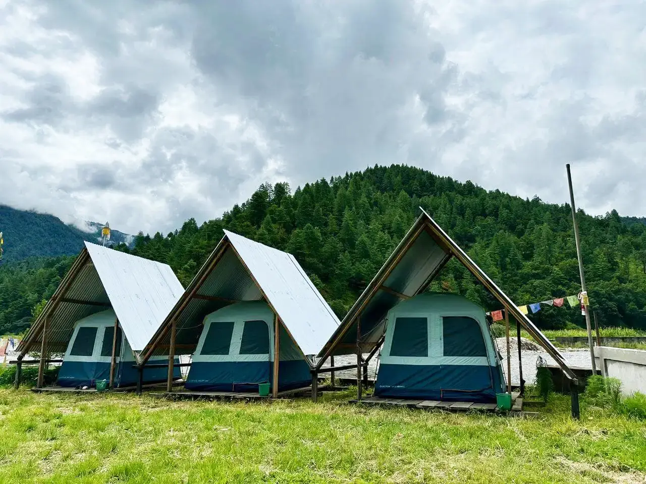 Luxury glamping tents by the riverside at Sangti Tsomka Campsite in Dirang